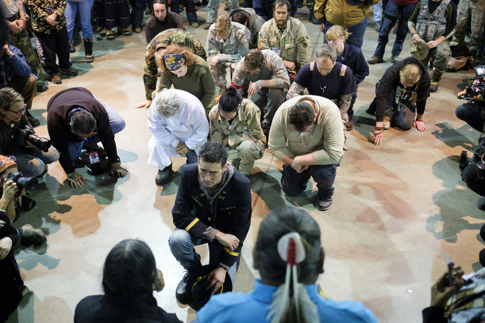 Gen. Wesley Clark Jr. and other veterans kneel in front of Leonard Crow Dog during a forgiveness ceremony at the Four Prairie Knights Casino & Resort on the Standing Rock Sioux Reservation on Monday, Dec. 5, 2016.